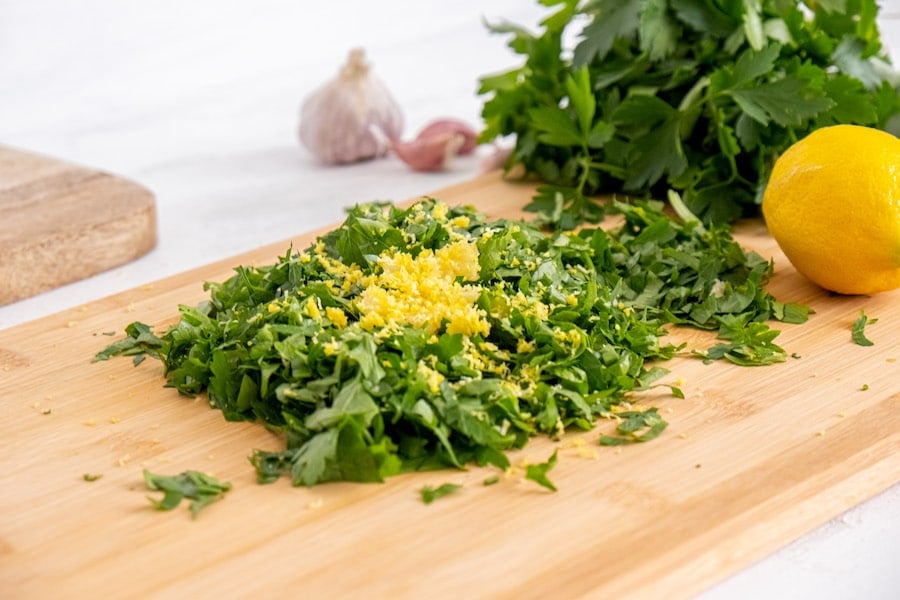 Lemon zest in parsley on cutting board