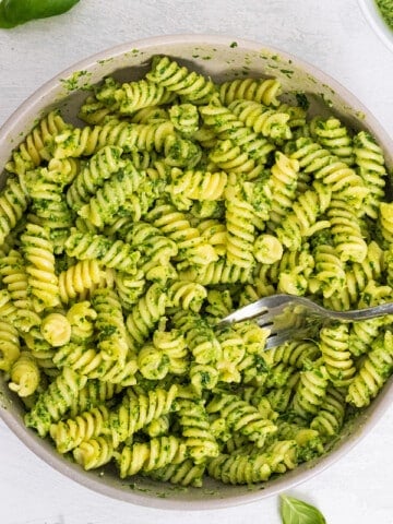 spinach pesto with pasta in white bowl