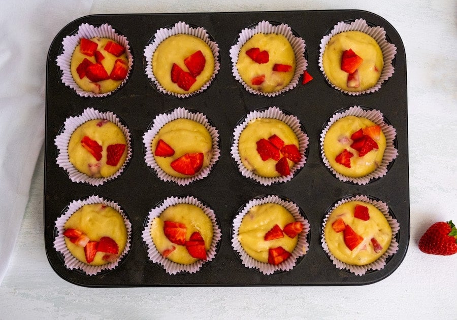muffin batter with berries in black tin