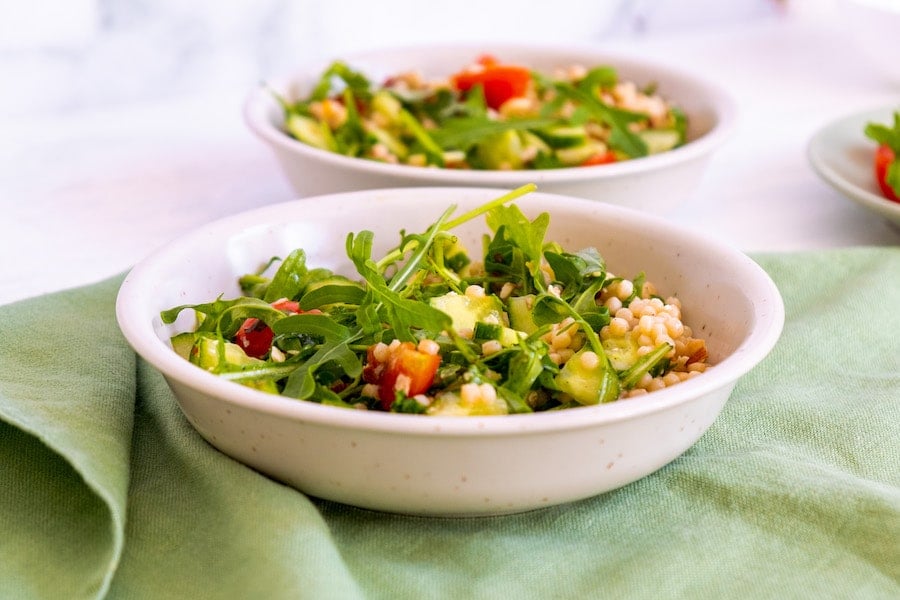 salads in white bowls on green table cloth