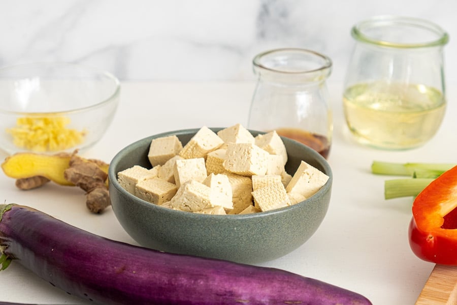 cubed tofu in green bowl with chinese eggplant