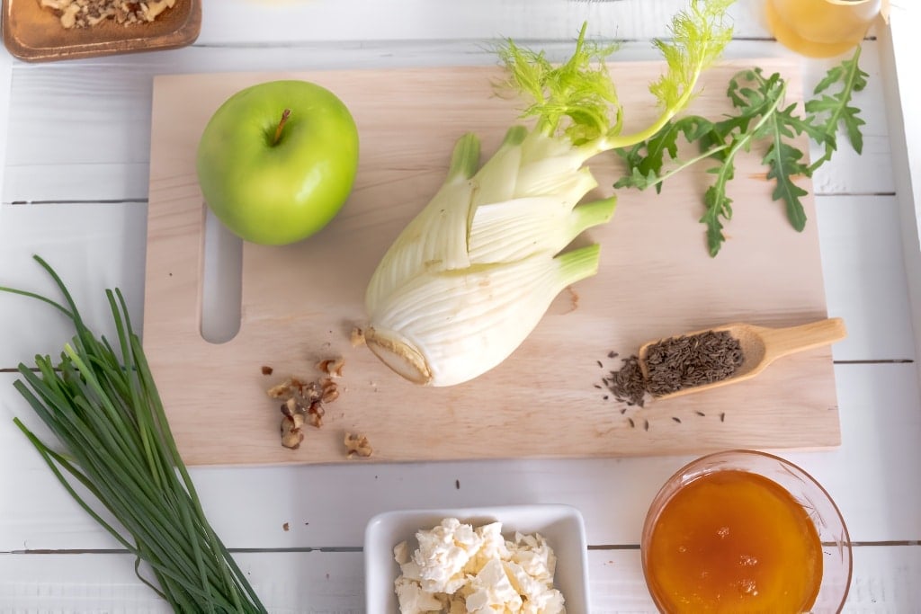 apple and walnut salad ingredients on wooden board
